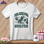 A white t-shirt hanging on a wooden background features a green eagle graphic and the text "Philadelphia #1 Quilter".