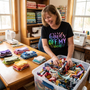 A quilter happily sorting her fabric scrap bin, wearing the Hands Off My Stash tee