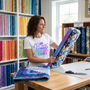 A quilter comparing wide backing fabric bolts, wearing the Sew Much Fabric Sew Little Time tee