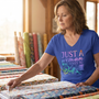A quilter in her studio choosing spring fabric colors, wearing the Just A Woman Who Loves To Quilt v-neck tee