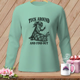 Mint green long-sleeve shirt featuring a black graphic of an otter tucking in a rabbit, with text reading TUCK AROUND AND FIND OUT.