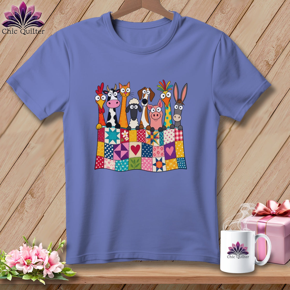 Blue t-shirt featuring a cartoon illustration of farm animals peeking over a colorful patchwork quilt.