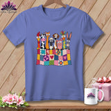 Blue t-shirt featuring a cartoon illustration of farm animals peeking over a colorful patchwork quilt.