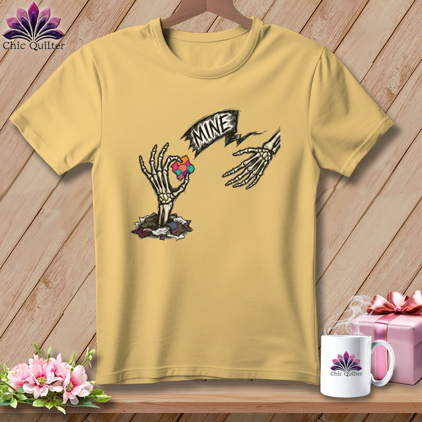 Yellow t-shirt with skeleton hands reaching for a puzzle piece, text "MINE".