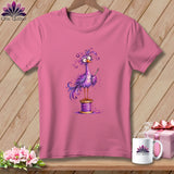 A pink t-shirt featuring a cartoon purple bird standing on a spool of thread while holding a needle.
