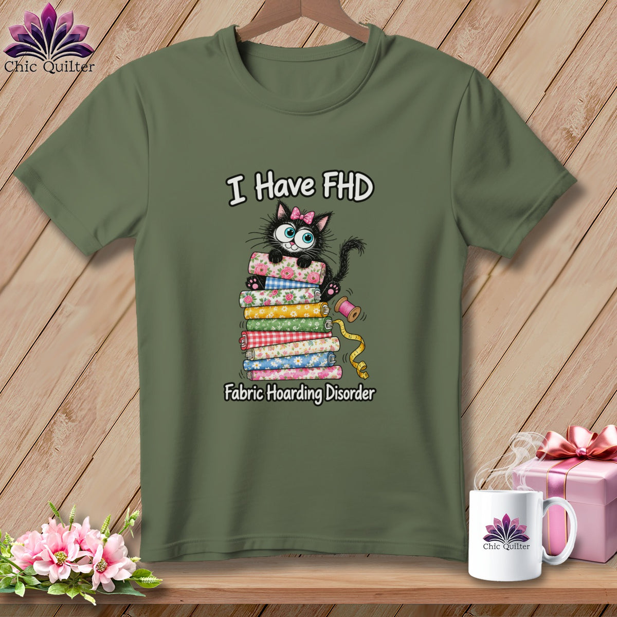 Olive green t-shirt with a graphic of a black cat on a stack of fabric and text reading I Have FHD Fabric Hoarding Disorder.