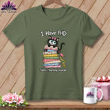 Olive green t-shirt with a graphic of a black cat on a stack of fabric and text reading I Have FHD Fabric Hoarding Disorder.