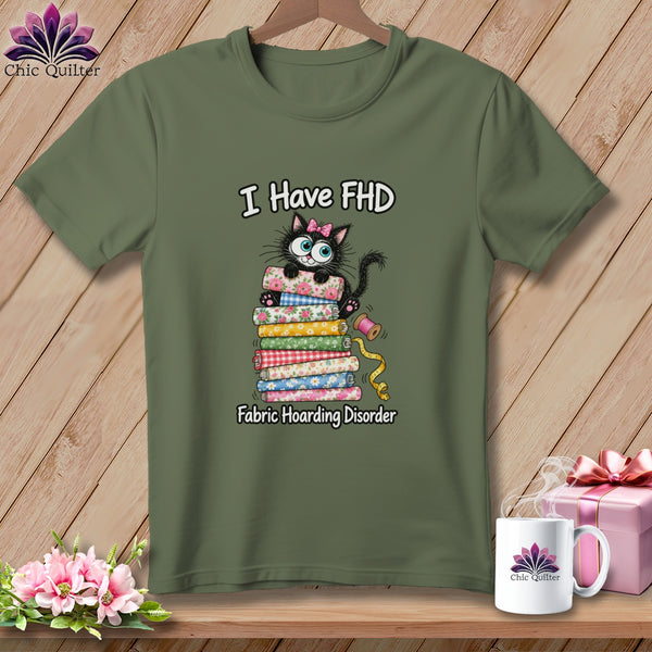 Olive green t-shirt with a graphic of a black cat on a stack of fabric and text reading I Have FHD Fabric Hoarding Disorder.
