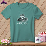 Teal t-shirt with a graphic of a quilted sun over rolling hills and the text 