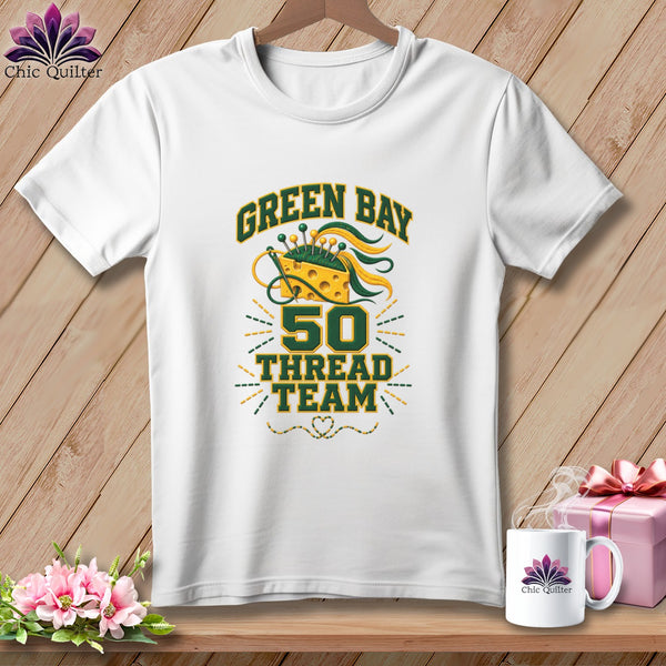 White crew-neck t-shirt featuring Green Bay 50 Thread Team typography, a cheese pincushion, and sewing tools graphic.