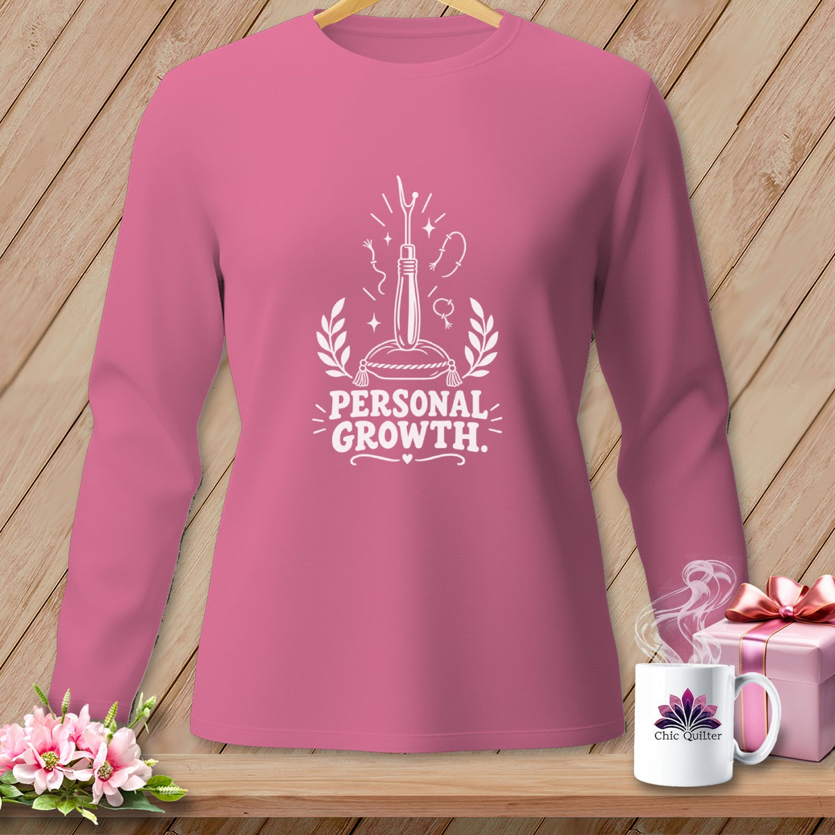 Pink long sleeve shirt with "Personal Growth" graphic and sewing needle.