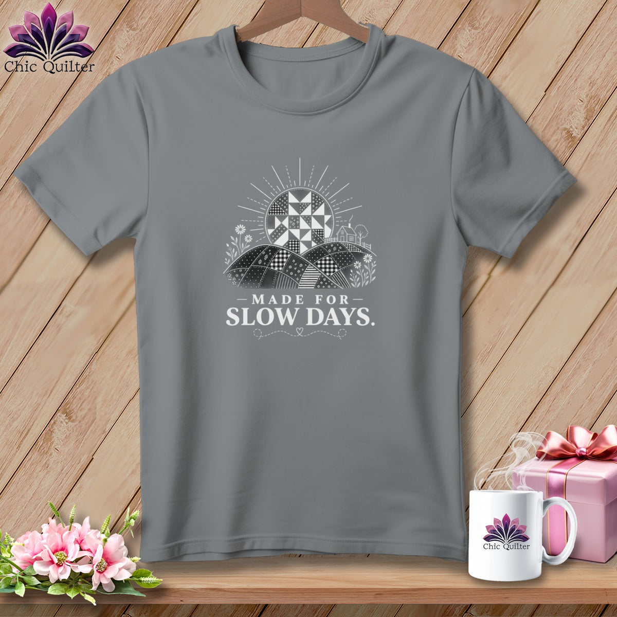 Grey t-shirt with a graphic of a quilt sun, fields, and "Made for Slow Days." text.