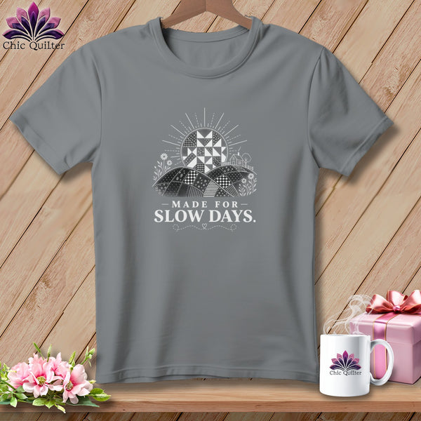 Grey t-shirt with a graphic of a quilt sun, fields, and "Made for Slow Days." text.