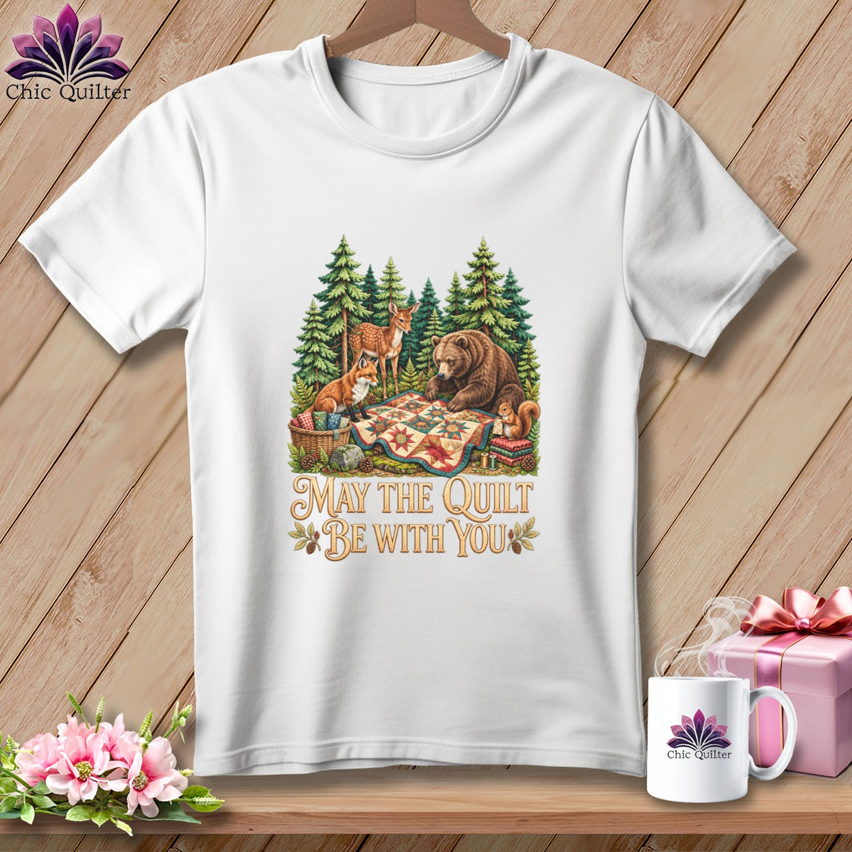 A white t-shirt features a woodland graphic with forest animals and the text May The Quilt Be With You.
