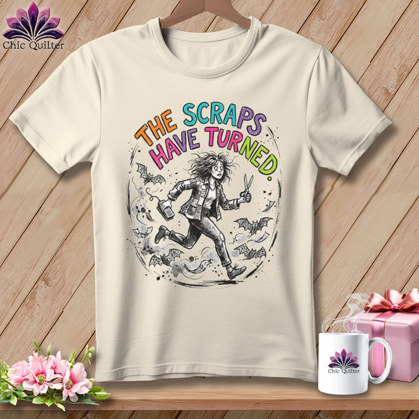 Cream t-shirt with graphic of woman running from bats, text reads "The Scraps Have Turned."