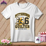 White t-shirt featuring a Pittsburgh Quilter graphic with a quilt block, rotary cutter, and number six.