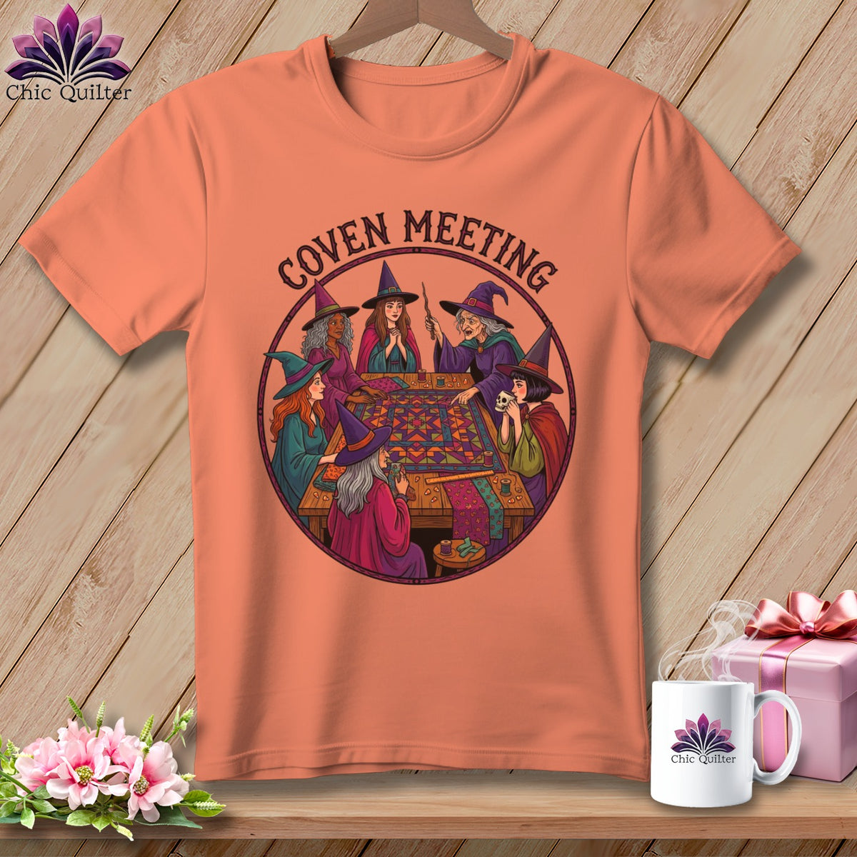 Peach t-shirt with "Coven Meeting" text and illustration of witches sewing.