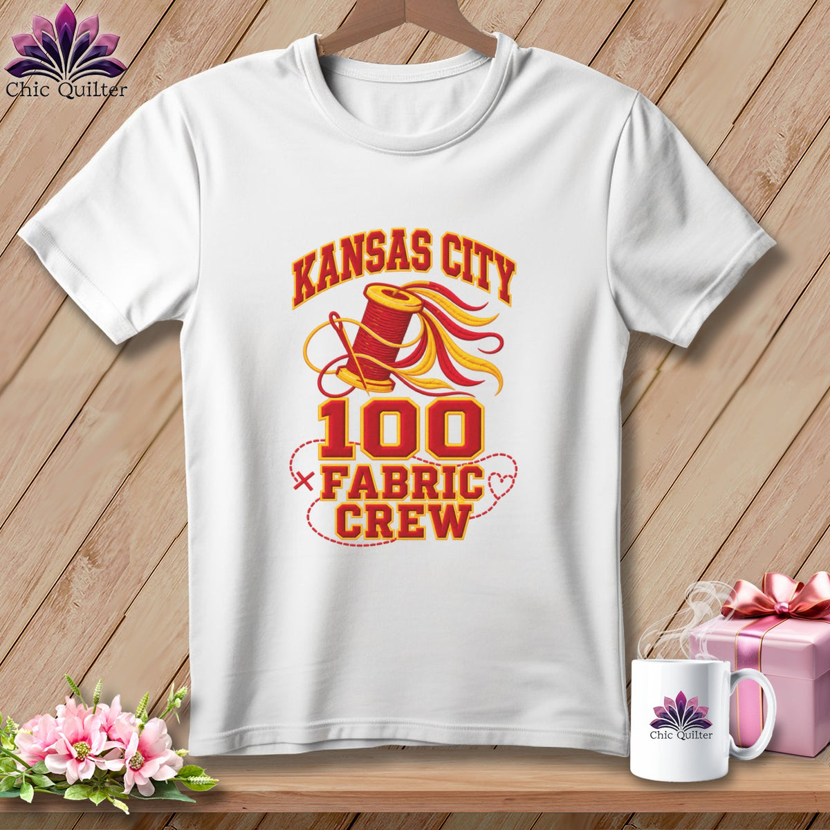 A white t-shirt hanging on a wooden background with a Kansas City 100 Fabric Crew graphic.