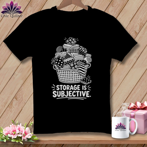 Black t-shirt with white graphic of fabric scraps in a basket and text "STORAGE IS SUBJECTIVE."
