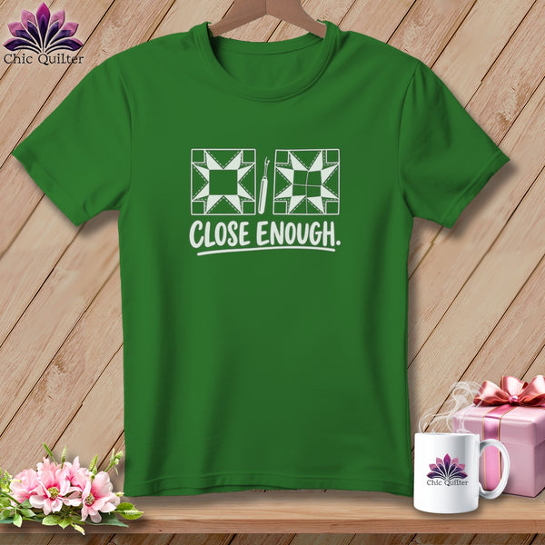 Green t-shirt with white quilting blocks, a seam ripper, and "CLOSE ENOUGH." text.