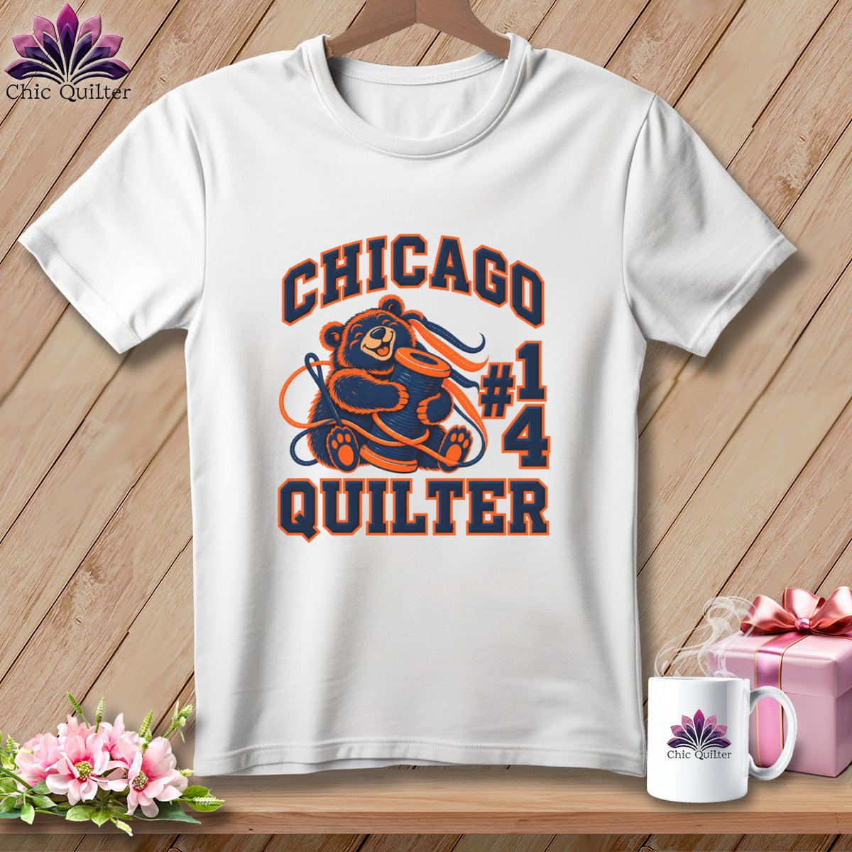 White crewneck t-shirt featuring a Chicago Quilter graphic with a bear hugging a thread spool.