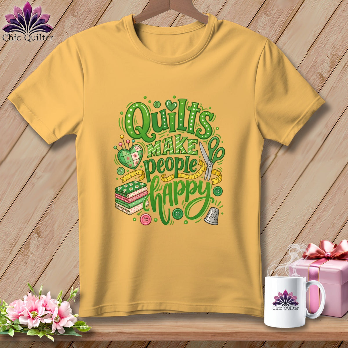 Yellow t-shirt hanging on a wooden background, featuring green text that reads Quilts Make People Happy.