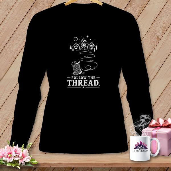 Black long-sleeve shirt with "Follow The Thread" text and sewing spool graphic.