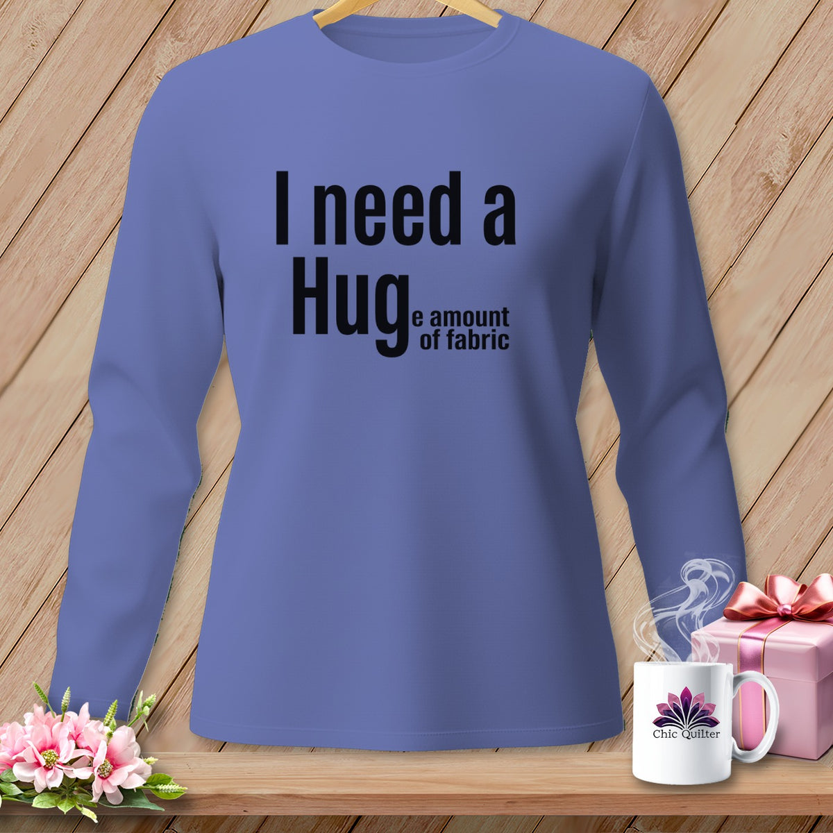 Periwinkle long-sleeve shirt with "I need a Hug, the amount of fabric" text.