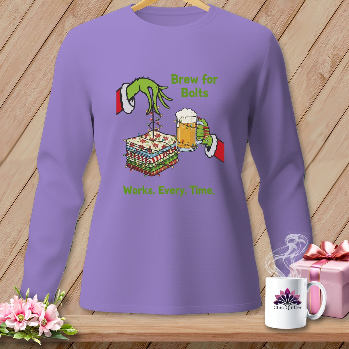 Purple sweatshirt with Grinch hand holding beer and fabric stacks, text "Brew for Bolts Works. Every. Time."