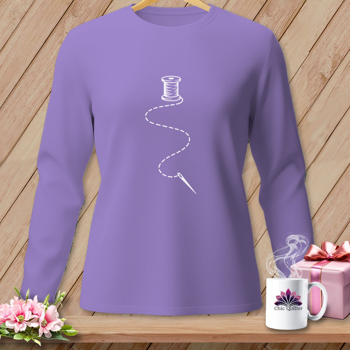 Purple long-sleeve shirt with a white spool of thread and needle graphic.