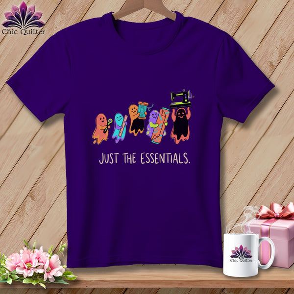 Purple t-shirt with ghosts carrying sewing supplies and text "JUST THE ESSENTIALS."