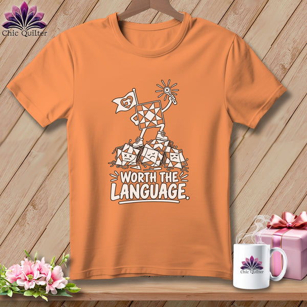 Orange t-shirt with a graphic of a quilt block character holding a flag and a sun, standing on sad quilt blocks.