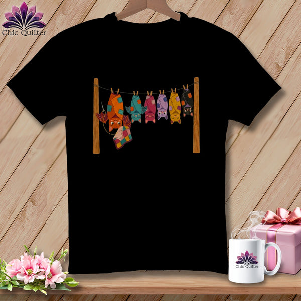 Black t-shirt with colorful bats hanging on a clothesline.