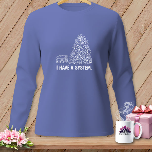Long-sleeved shirt with a pile of fabric scraps and text "I HAVE A SYSTEM."