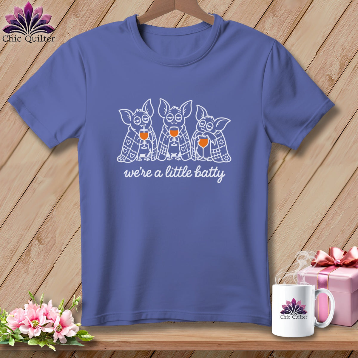 Purple t-shirt with three bats holding wine glasses and the text "we're a little batty".