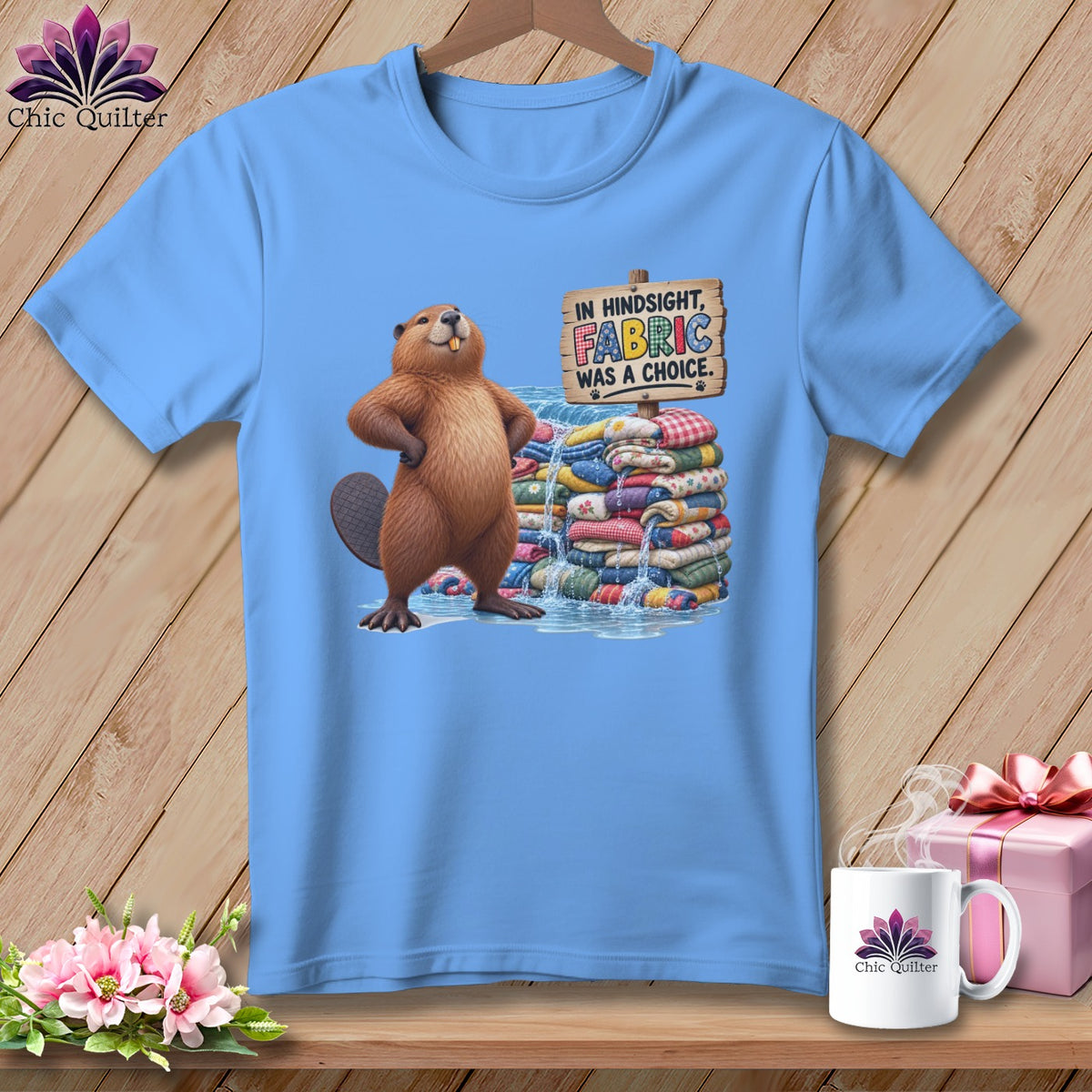 Light blue t-shirt with a beaver and stack of fabric, text reads "In hindsight, fabric was a choice."