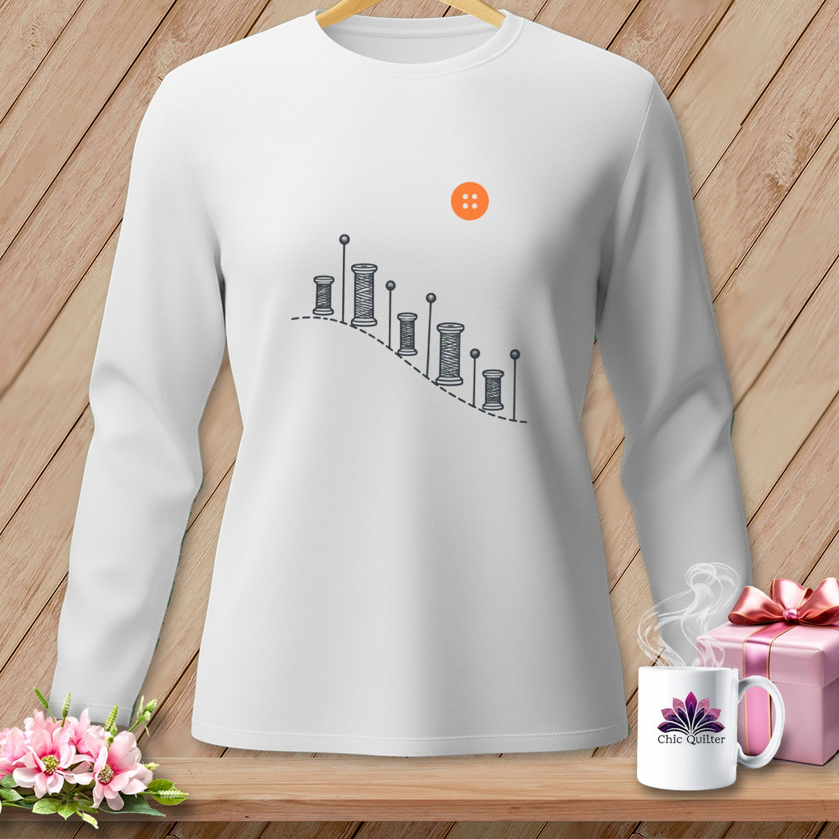 White long-sleeved shirt with sewing graphic and orange button detail.