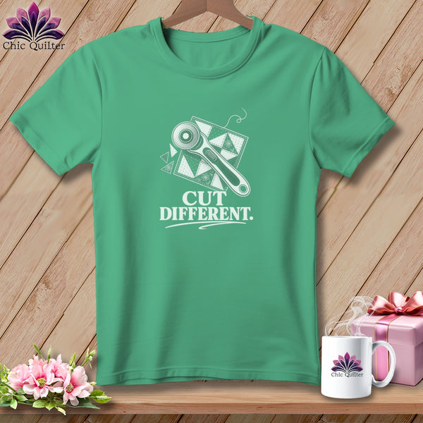 Teal t-shirt with rotary cutter and quilt block graphic, reading "CUT DIFFERENT."