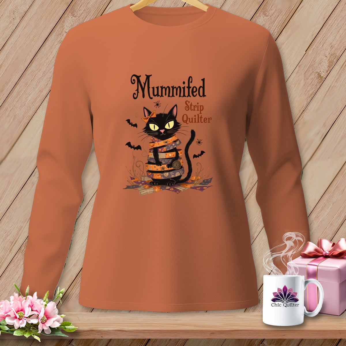 Black cat wrapped in quilting strips with bats and spiders, "Mummified Strip Quilter" text.