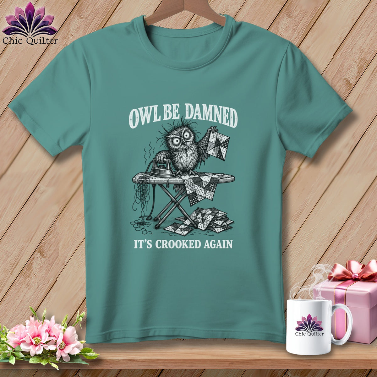 T-shirt with an owl ironing crooked quilt pieces, text "OWL BE DAMNED, IT'S CROOKED AGAIN".