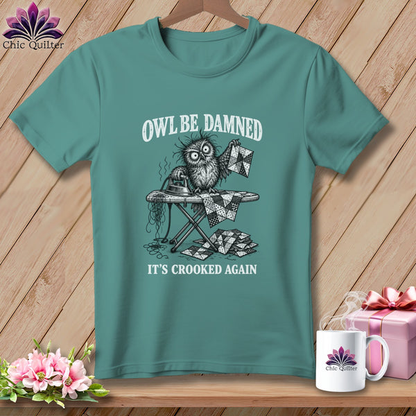 T-shirt with an owl ironing crooked quilt pieces, text "OWL BE DAMNED, IT'S CROOKED AGAIN".