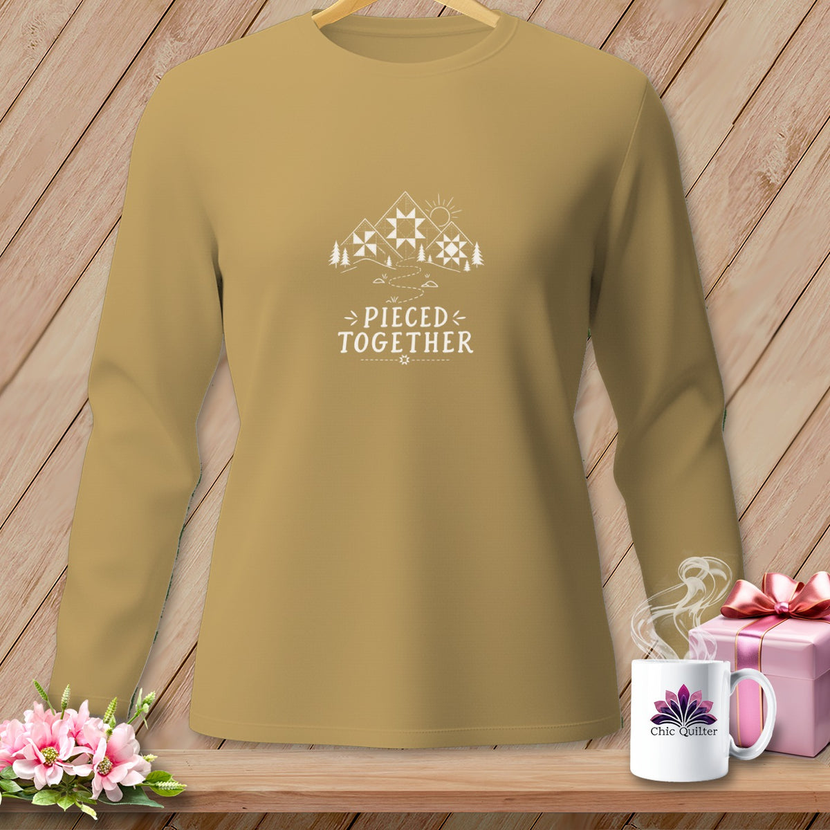 Tan long-sleeve shirt with "Pieced Together" text and mountain quilt graphic.