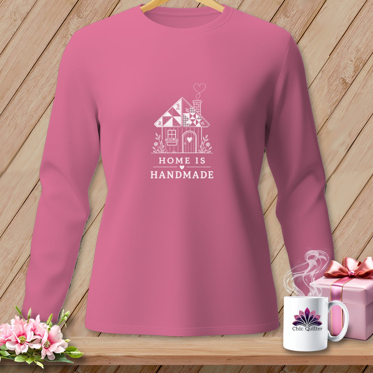 Pink long-sleeved shirt with white "Home is Handmade" house graphic.