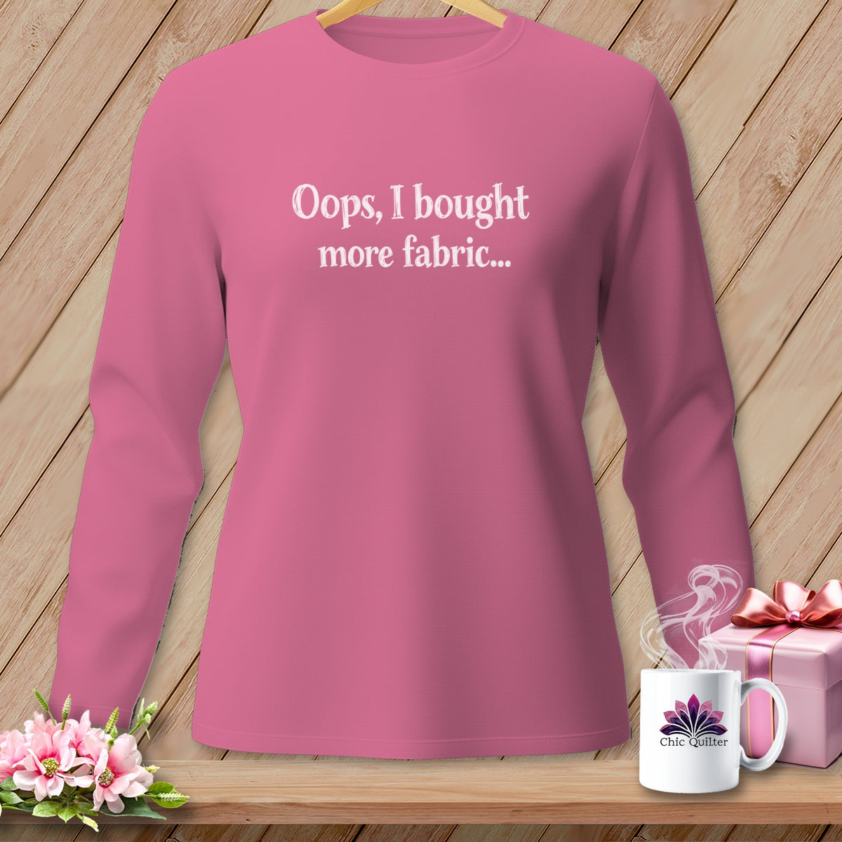 Pink long-sleeve shirt with white text "Oops, I bought more fabric..."