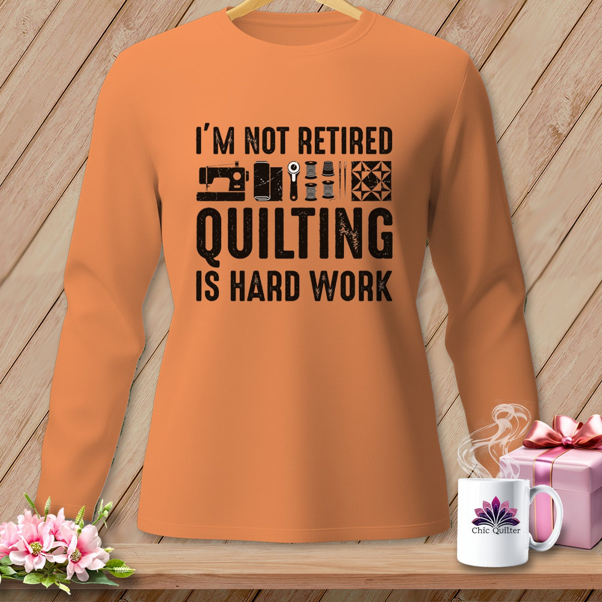 Orange long-sleeve shirt with "I'm not retired quilting is hard work" graphic.