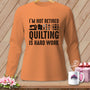 Orange long-sleeve shirt with "I'm not retired quilting is hard work" graphic.