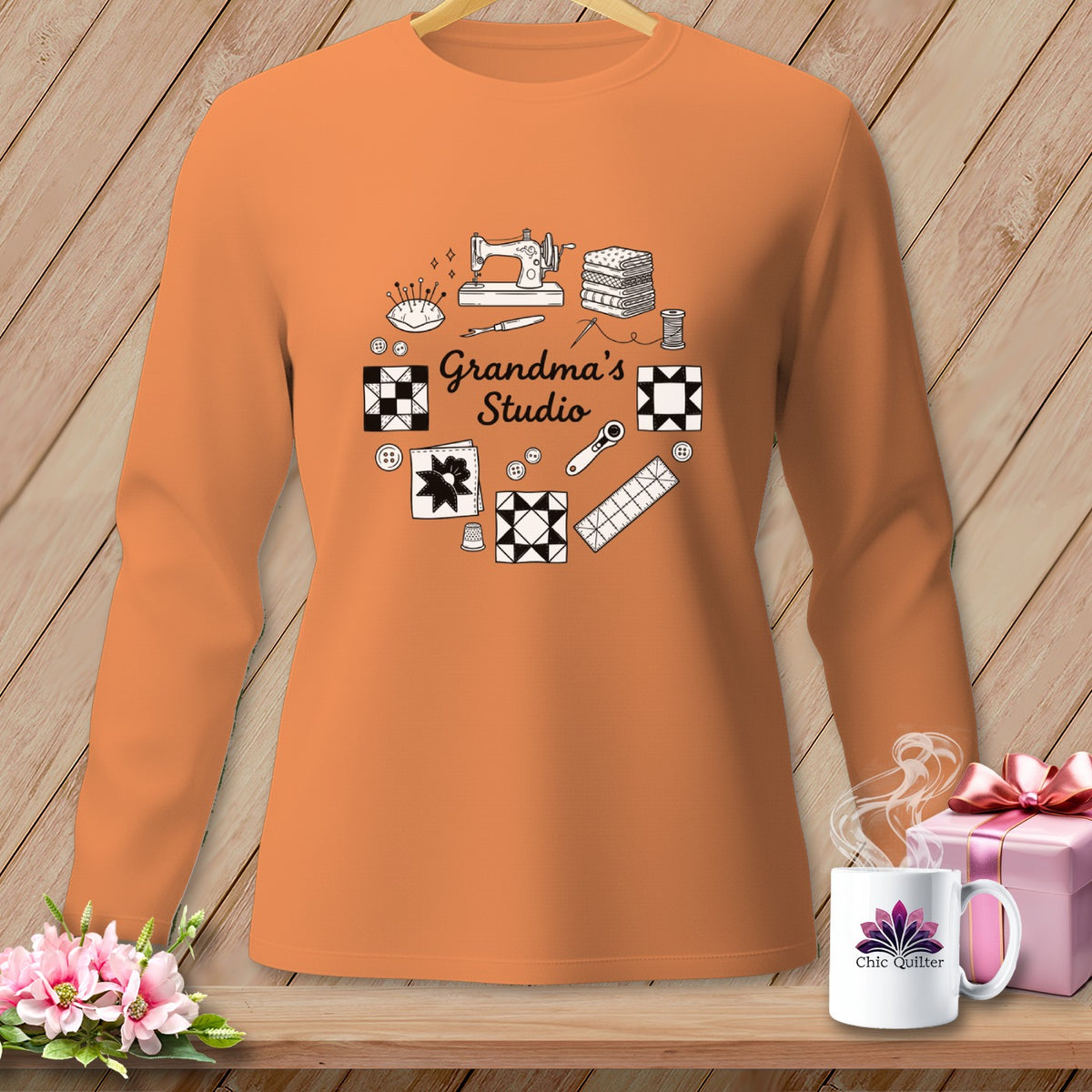 Orange long-sleeve shirt with "Grandma's Studio" and sewing icons design.