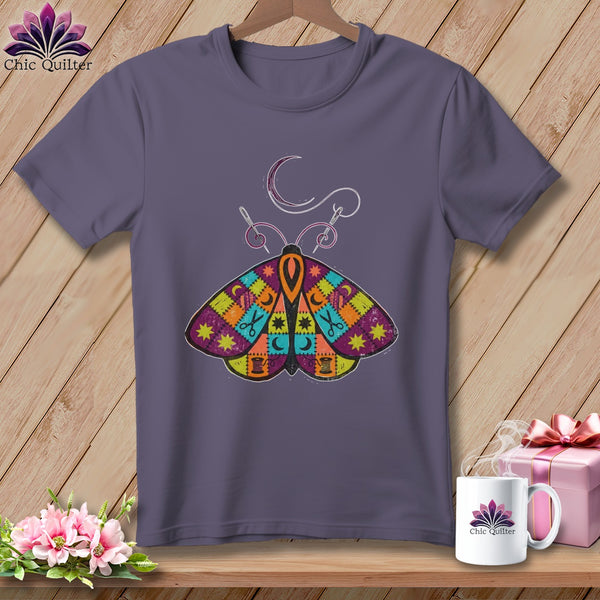 Purple t-shirt with a colorful patchwork butterfly design and sewing notions.