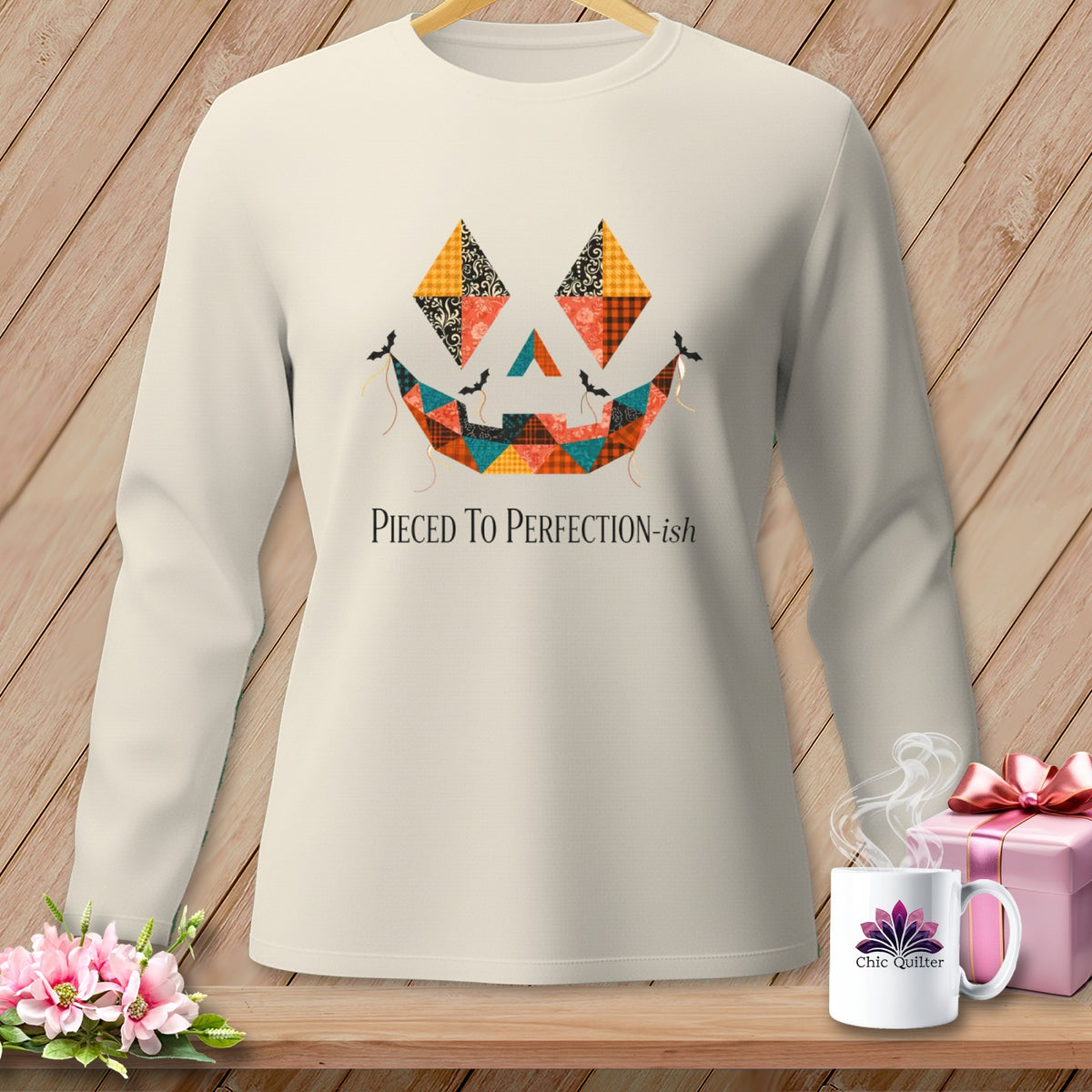 Cream long-sleeve shirt with a patchwork jack-o'-lantern face and bats.