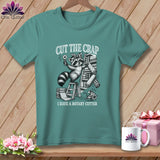T-shirt graphic of a raccoon with a rotary cutter and fabric.